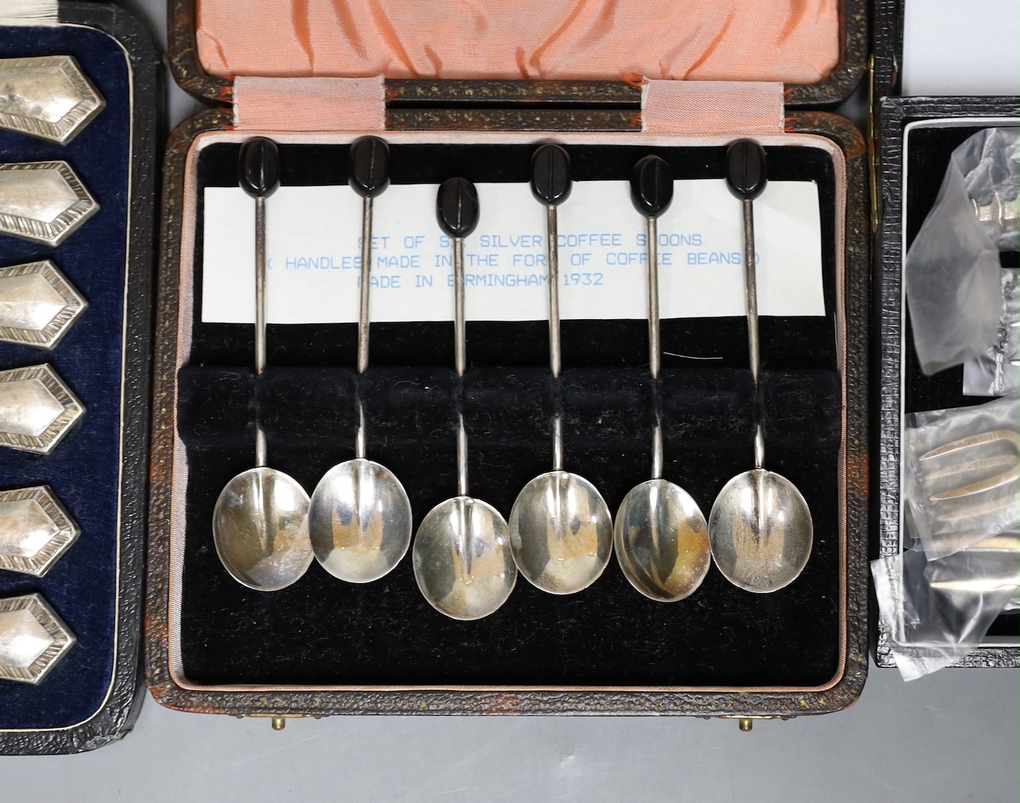 Three assorted cased sets including six silver handled tea knives, six bean end coffee spoons and six sterling cocktail forks.